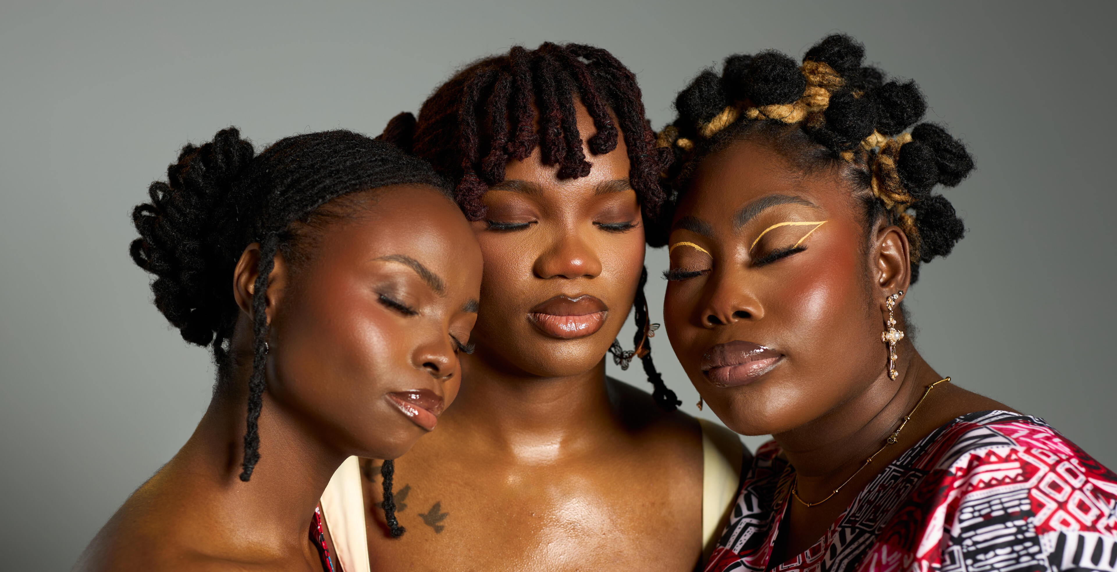 3 women with locs, holding each other